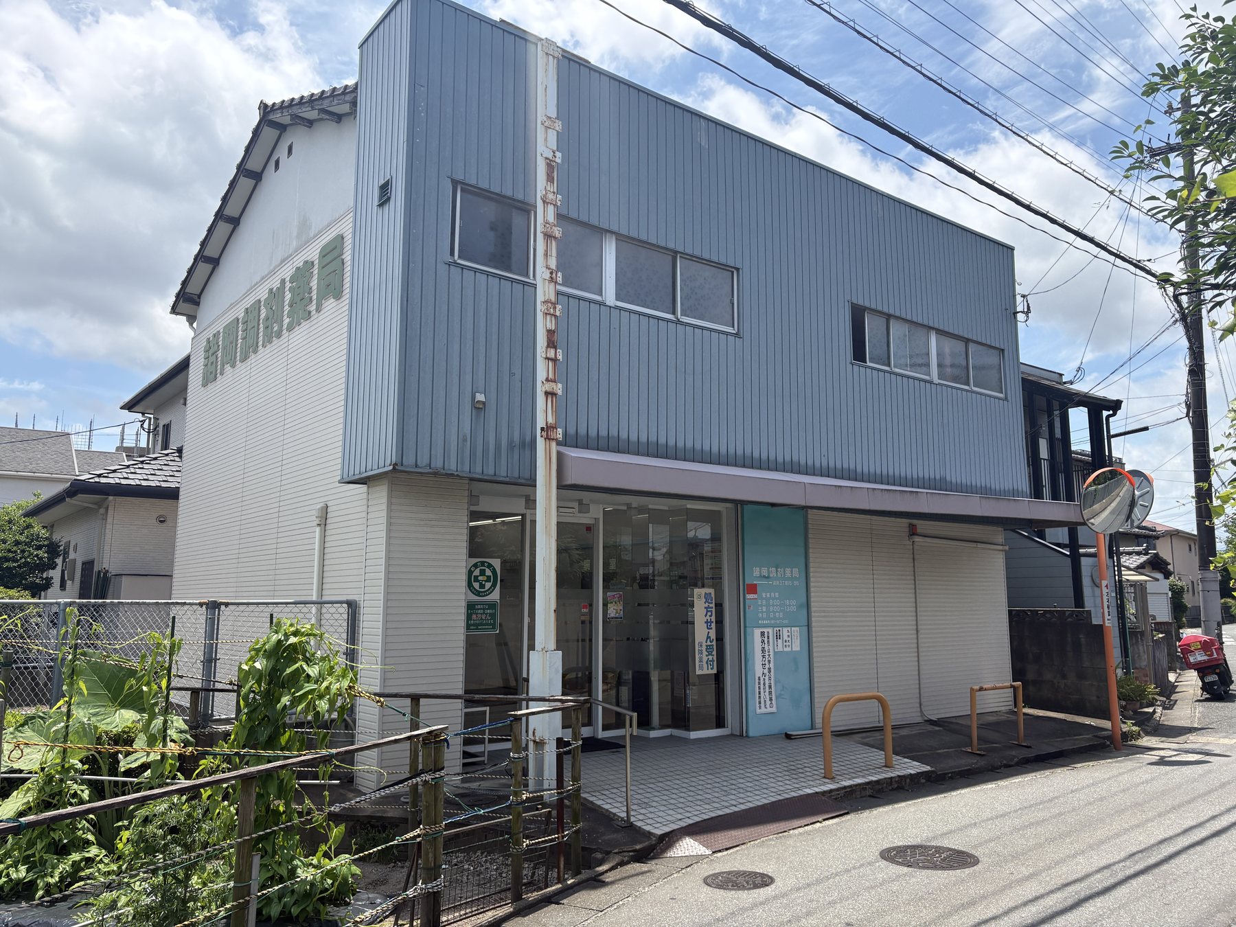 青い外壁の諸岡調剤薬局の外観
